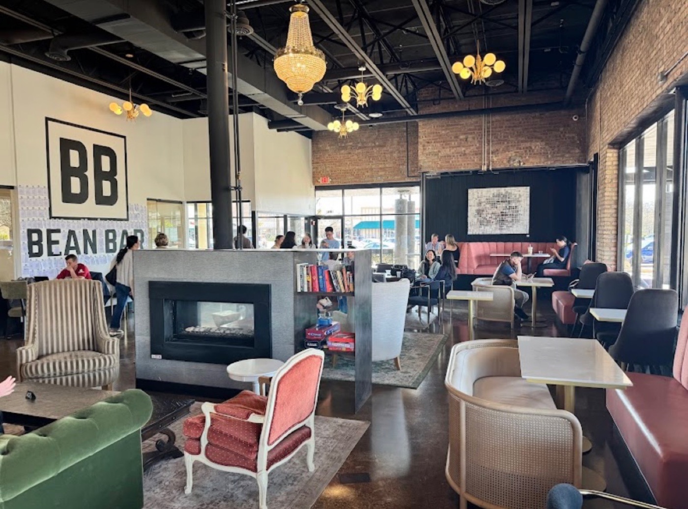 The sunlit lounge with the BB mural, chandeliers, banquettes, and guests gathered at tables